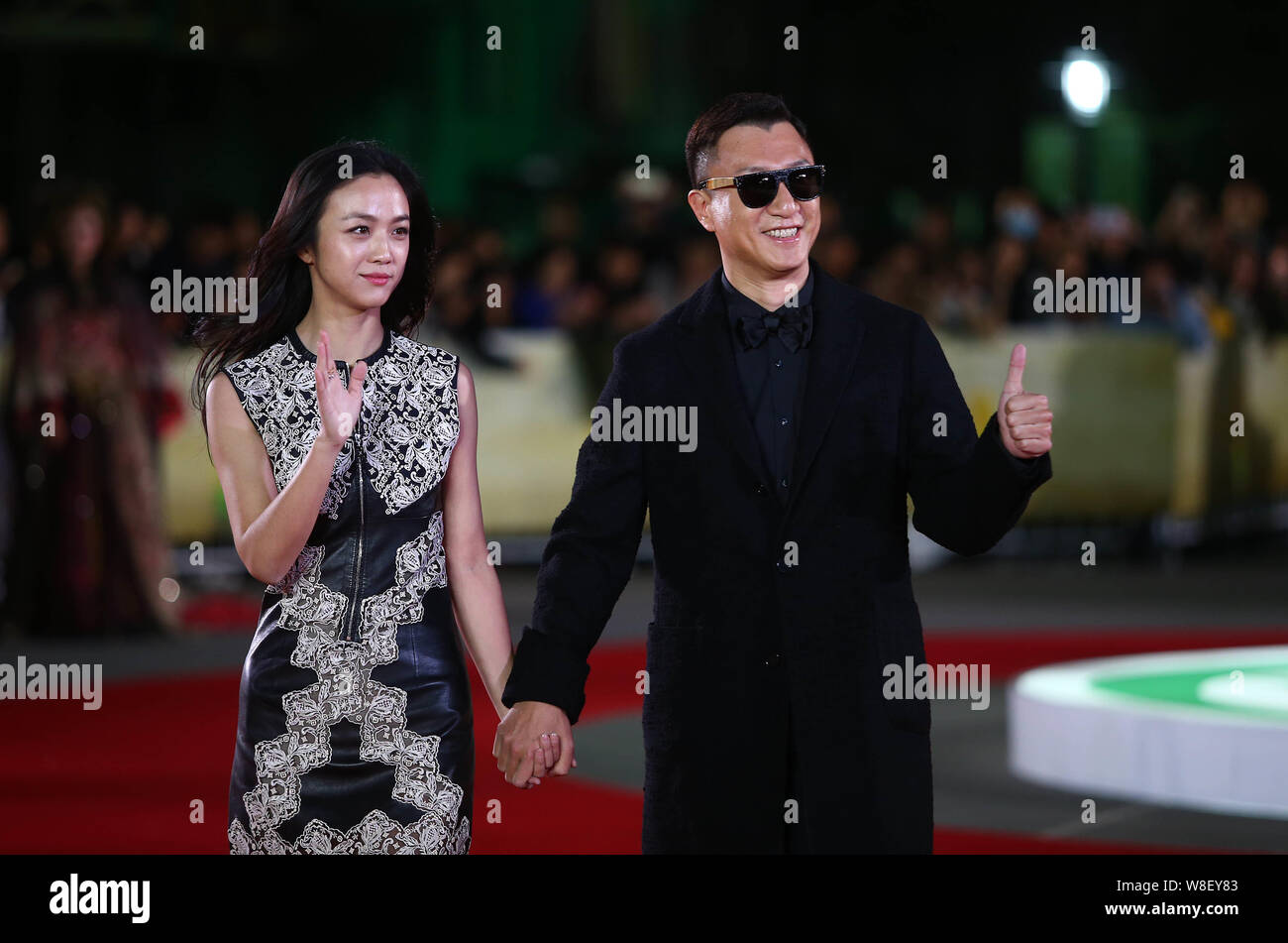 Chinese actress Tang Wei, left, and actor Sun Honglei wave as they arrive at the red carpet for the 5th International Theatre Academy Award (Acting Aw Stock Photo
