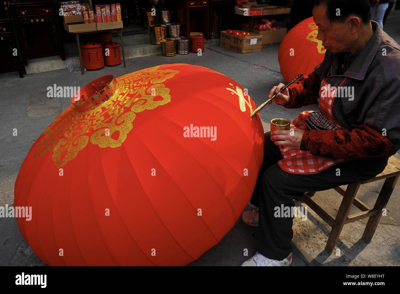 A Chinese worker is writing the Chinese character "Chun", meaning