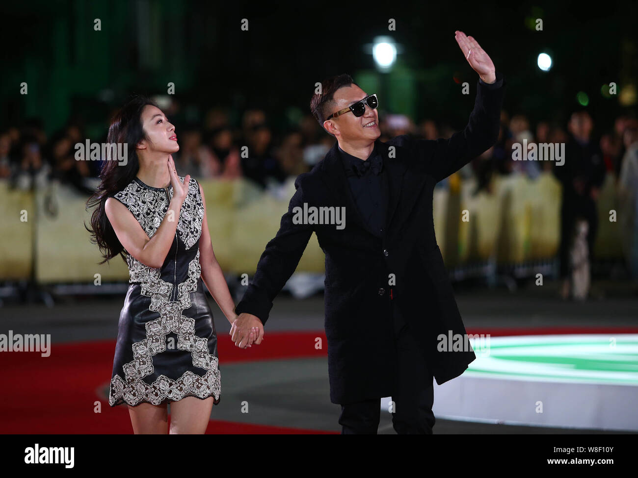 Chinese actress Tang Wei, left, and actor Sun Honglei wave as they arrive at the red carpet for the 5th International Theatre Academy Award (Acting Aw Stock Photo