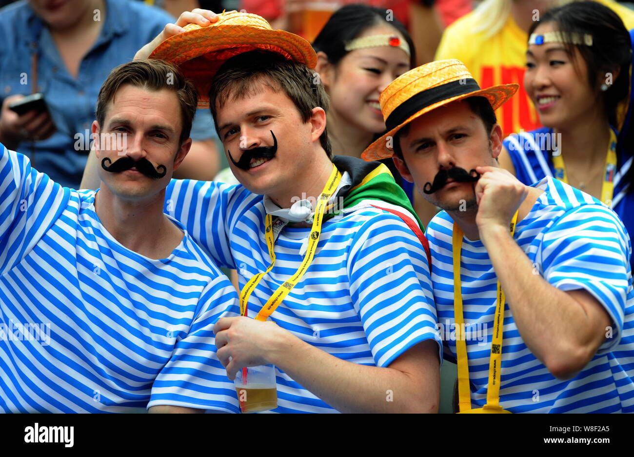 Fans wearing false beard pose for photos during a rugby match of the Hong Kong Seven 2015 in Hong Kong, China, 28 March 2015.   At the Hong Kong Rugby Stock Photo