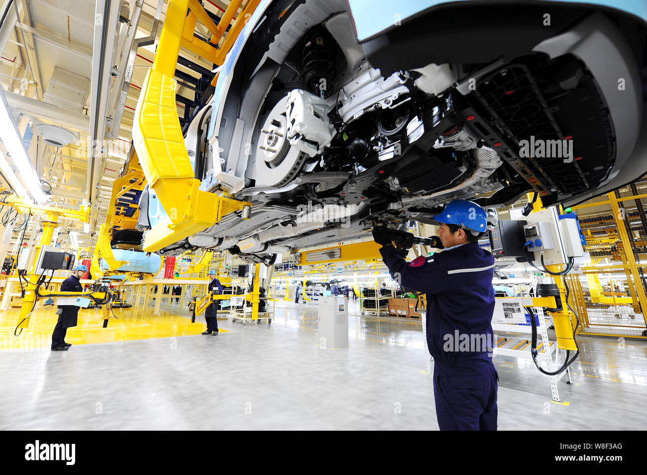 Chinese workers assemble Ford SUVs on the assembly line at the auto ...