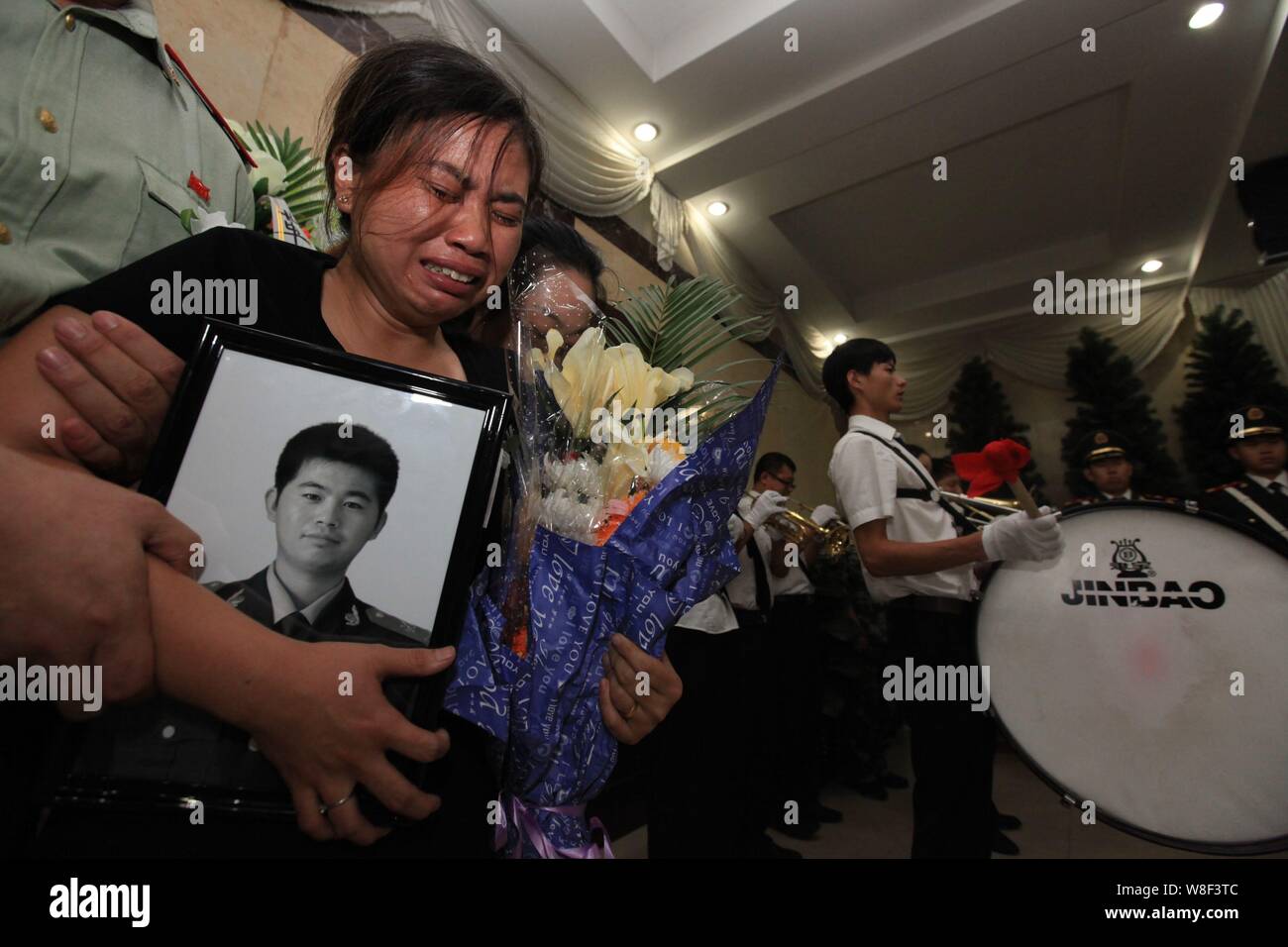 --FILE--A family member of Chinese firefighter Tian Baojian who was killed in the massive explosions in Binhai New Area, weeps during a funeral in Tia Stock Photo