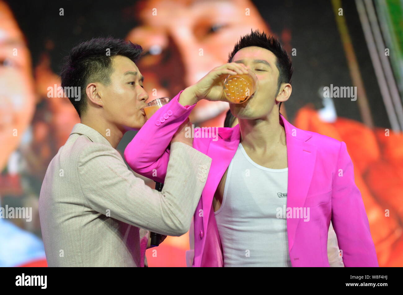 Chinese actors Tong Dawei, left, and Huang Xiaoming drink cross ...