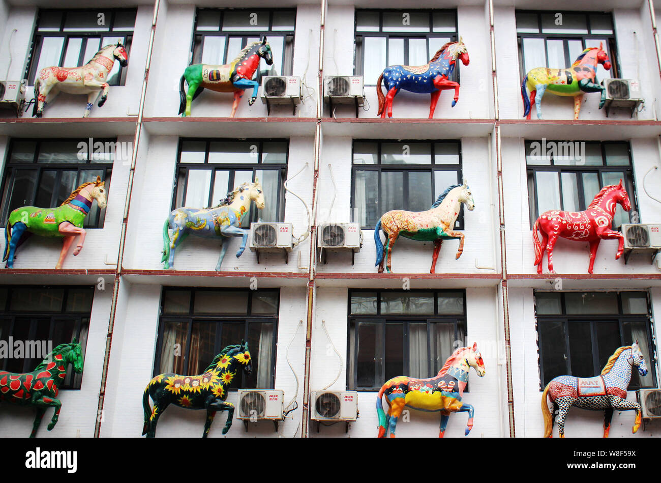 Horse sculptures are on display outside the windows of guest rooms in a hotel building in Chongqing, China, 21 November 2015.   Though the Year of the Stock Photo