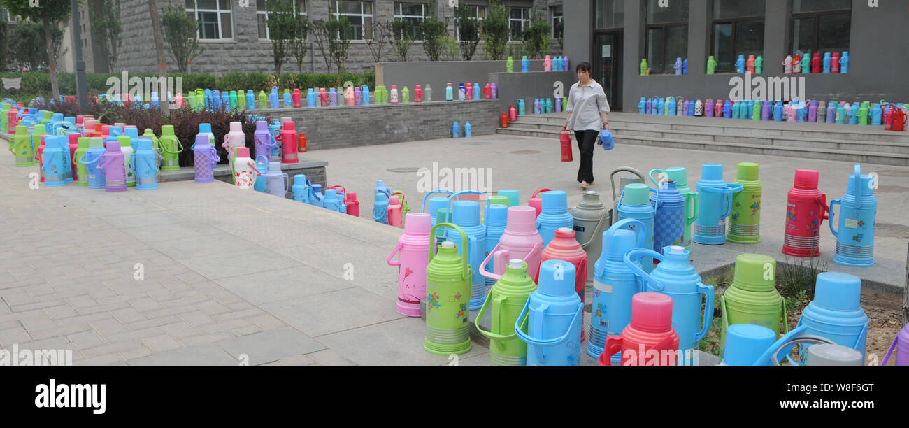 Colorful thermos flasks are placed by students in front of the public water room on the campus of Shanxi University of TCM in Jinzhong city, north Chi Stock Photo