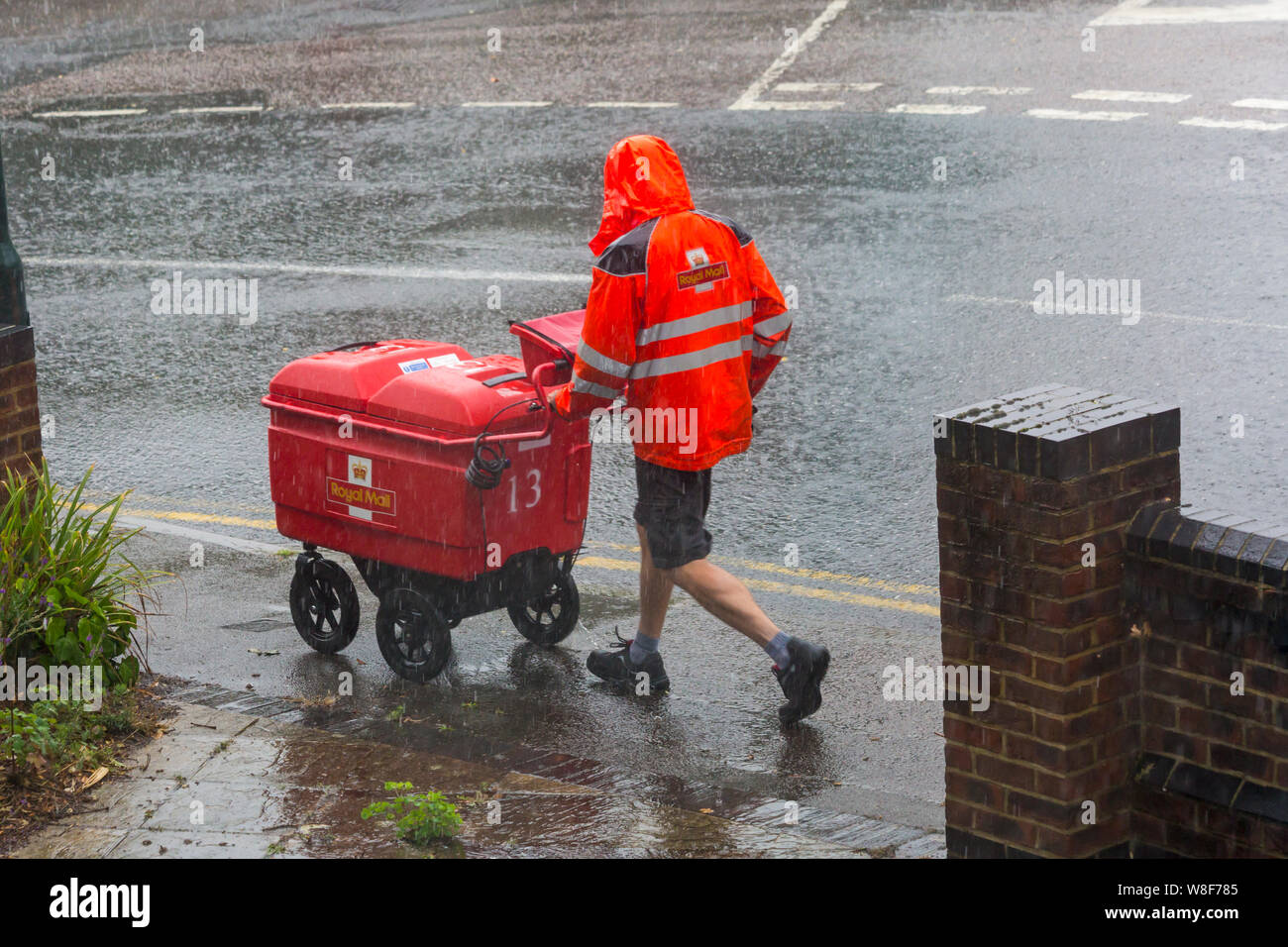 Bournemouth, Dorset UK. 9th Aug 2019. UK weather: the bad weather has arrived as torrential rain falls in Bournemouth. Postman wearing shorts hurries on his rounds regardless of the weather!  Credit: Carolyn Jenkins/Alamy Live News Stock Photo