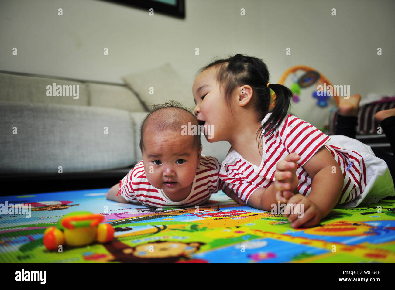FILE--Three-year-old girl Niu Niu speaks to her four-month-old sister at  home in Fuzhou city, southeast China's Fujian province, 26 May 2015. Gove  Stock Photo - Alamy