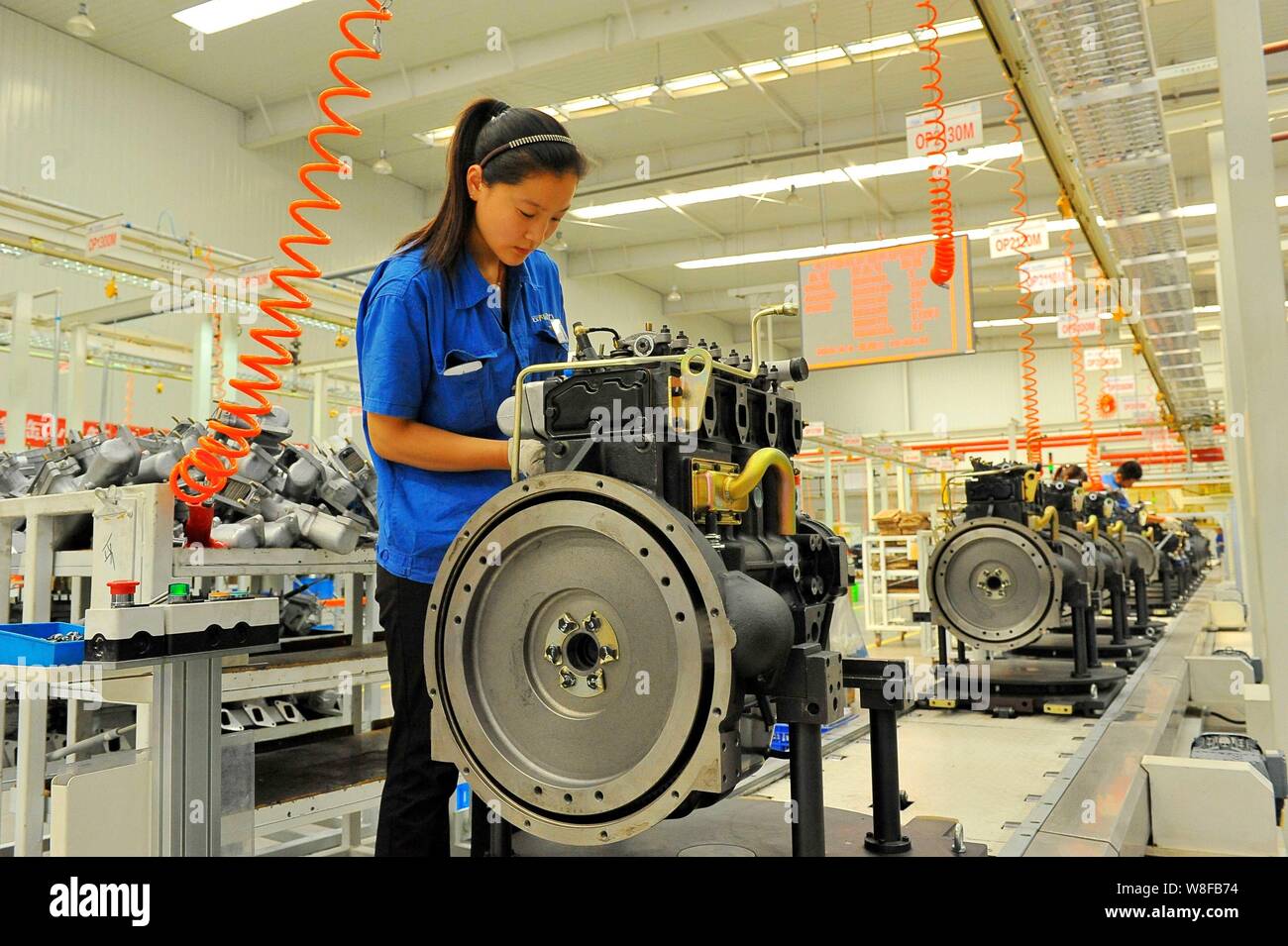 --FILE--A Chinese worker assembles engines on the assembly line at an ...