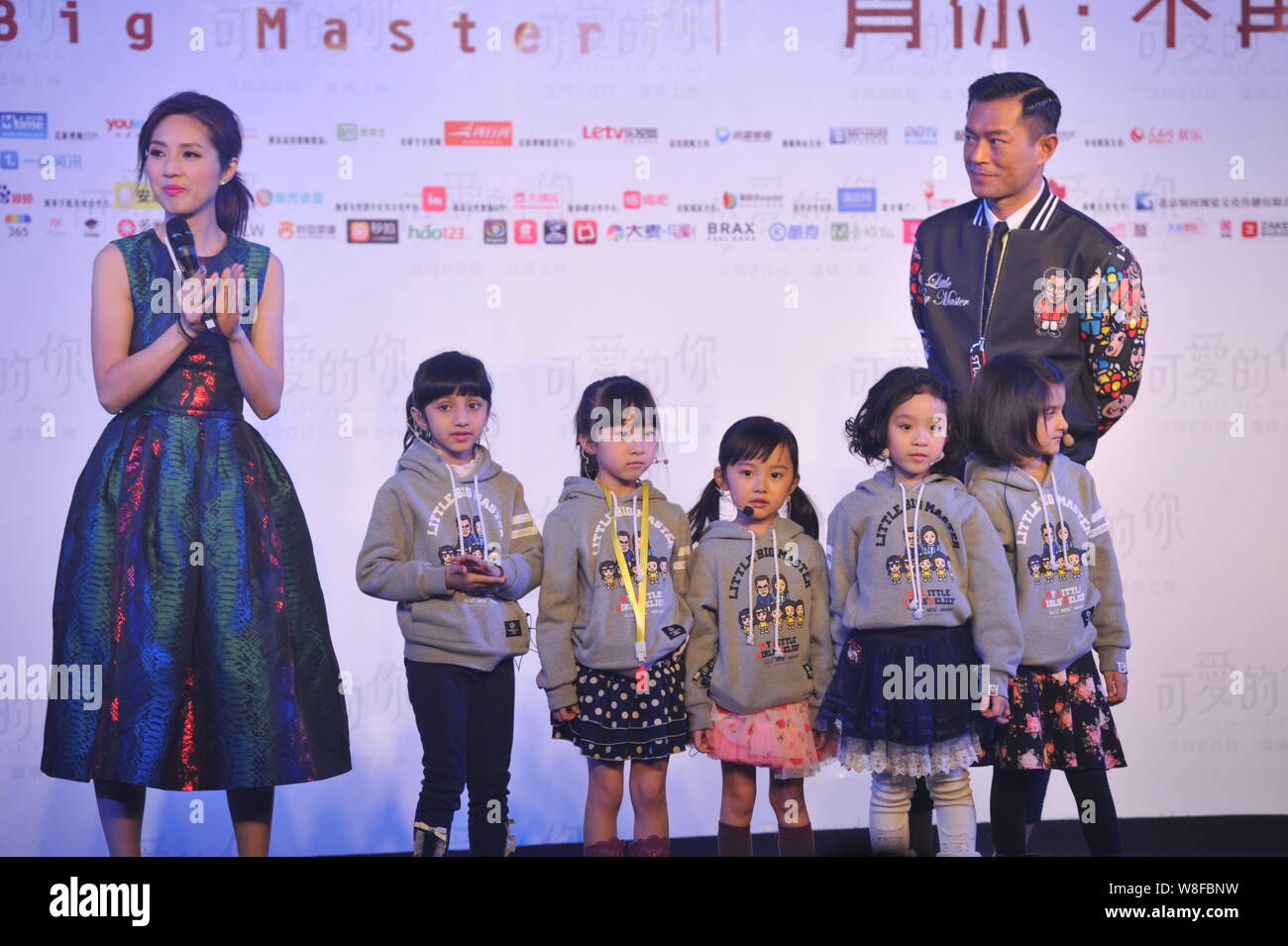 Hong Kong actress Miriam Yeung, left, and actor Louis Koo, right, pose with  young girls during the premiere for their new movie 
