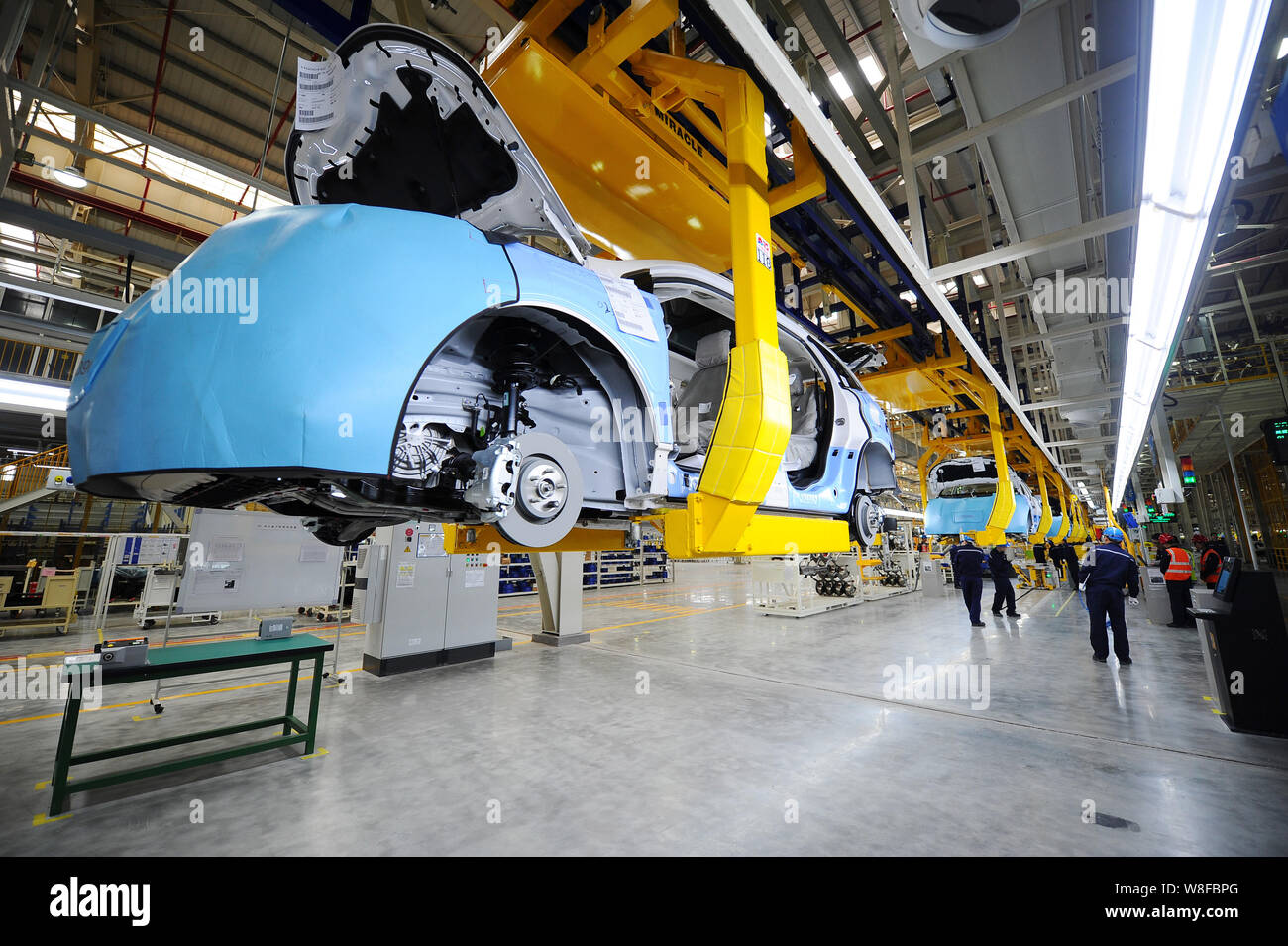Chinese workers assemble Ford SUVs on the assembly line at the auto ...