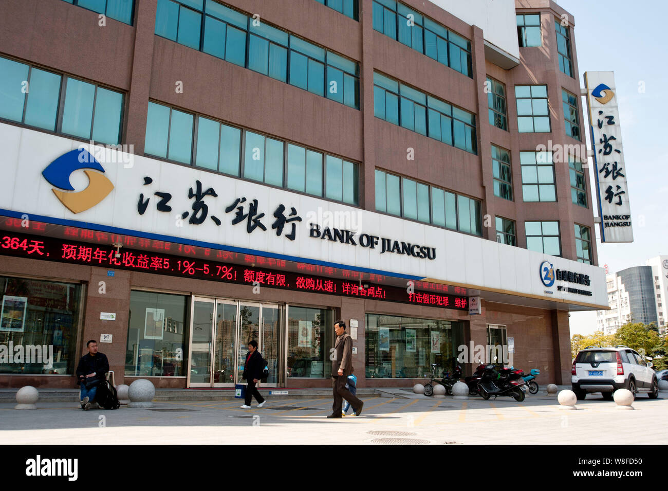 --FILE--Pedestrians walk past a branch of Bank of Jiangsu in Hai'an county, east China's Jiangsu province, 6 April 2014.     An impending listing for Stock Photo