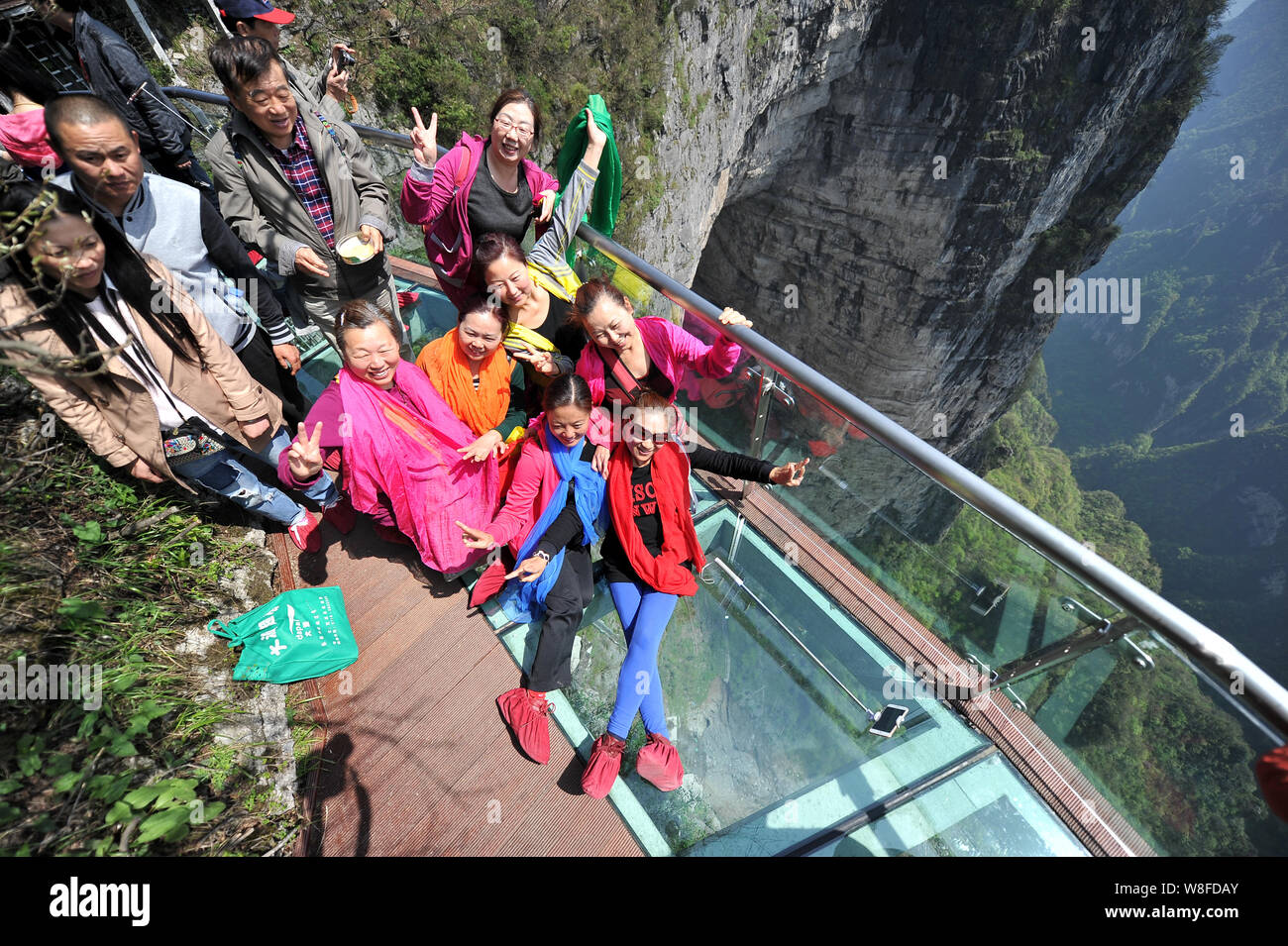 Tourists Pose For Photos On The Glass Skywalk On The Cliff Of Tianmen Mountain Or Tianmenshan Mountain In Zhangjiajie National Forest Park In Zhangj Stock Photo Alamy