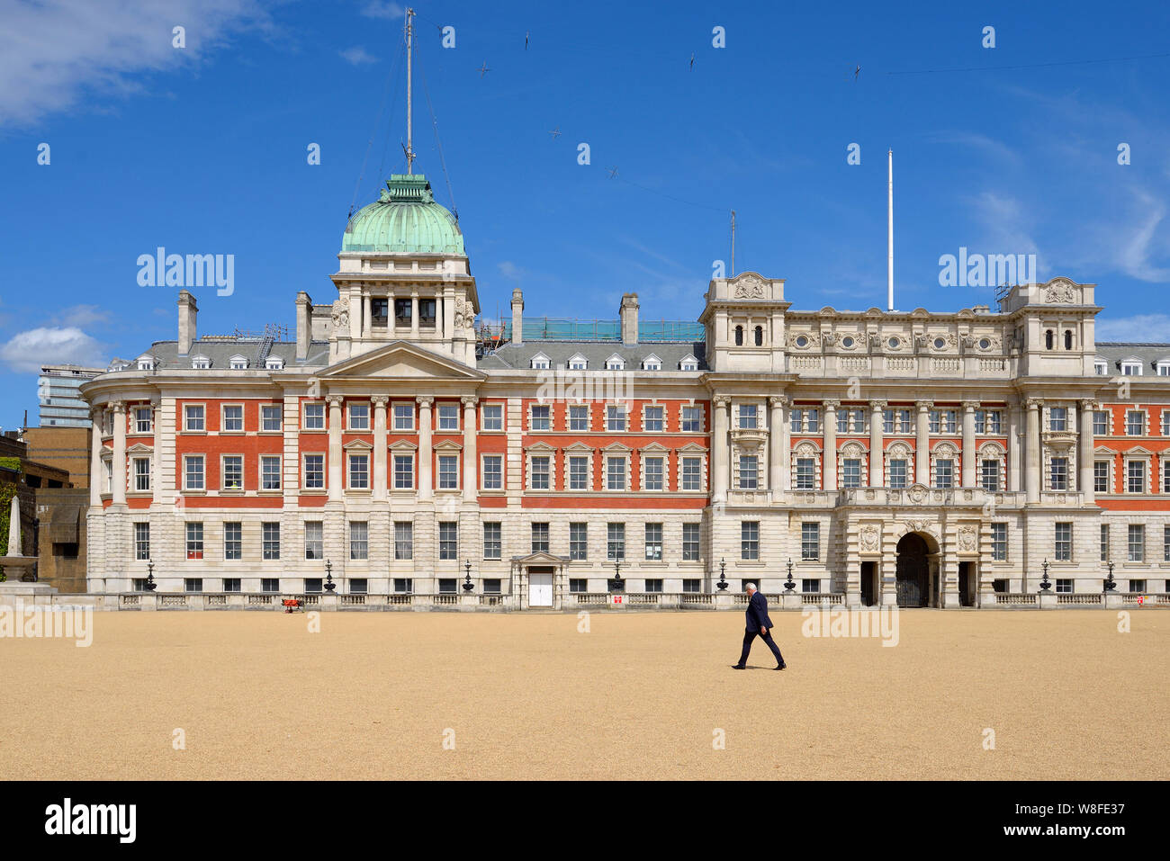 London, England, UK. Businessman walking acros Horse Guards Parade, looking north to the Old Admiralty Building Stock Photo