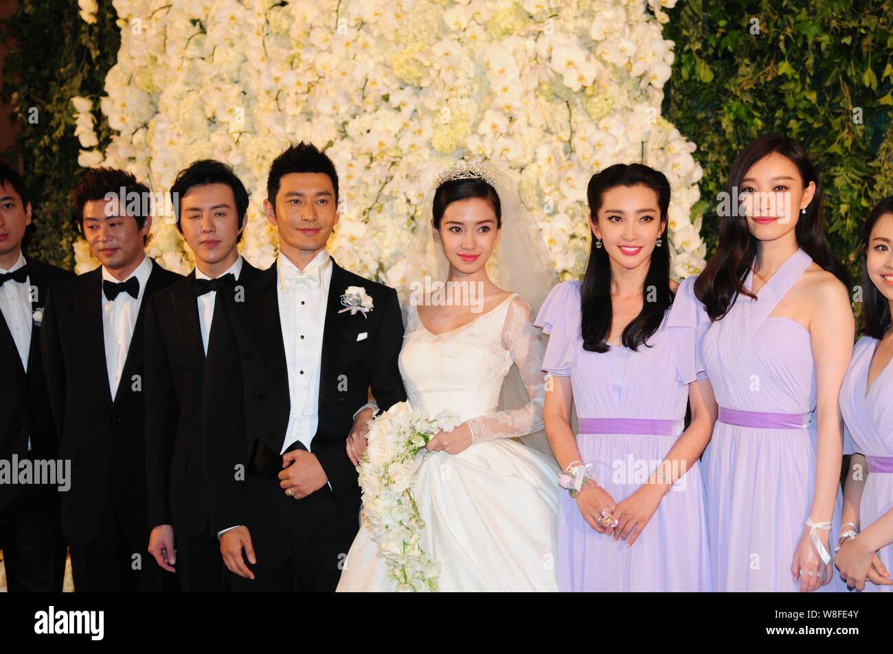 Chinese actor Huang Xiaoming, fourth left, and his actress wife Angelababy, fourth right, pose with their groomsmen and bridesmaids during their weddi Stock Photo