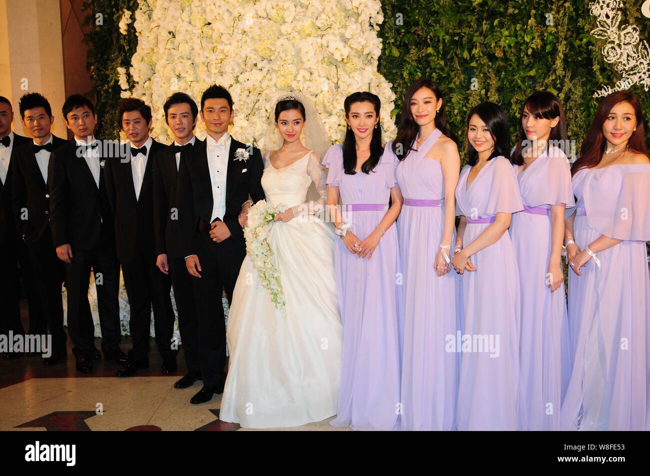 Chinese actor Huang Xiaoming, sixth left, and his actress wife Angelababy, sixth right, pose with their groomsmen and bridesmaids during their wedding Stock Photo