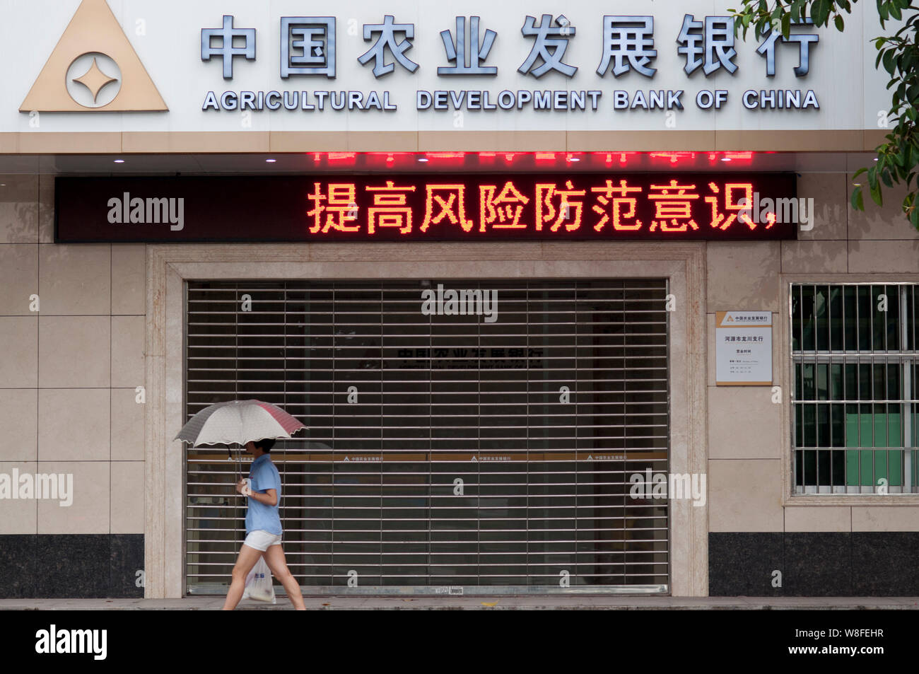--FILE--A pedestrian walks past a branch of the Agricultural Development Bank of China (ADBC) in Heyuan city, south China's Guangdong province, 22 Jun Stock Photo