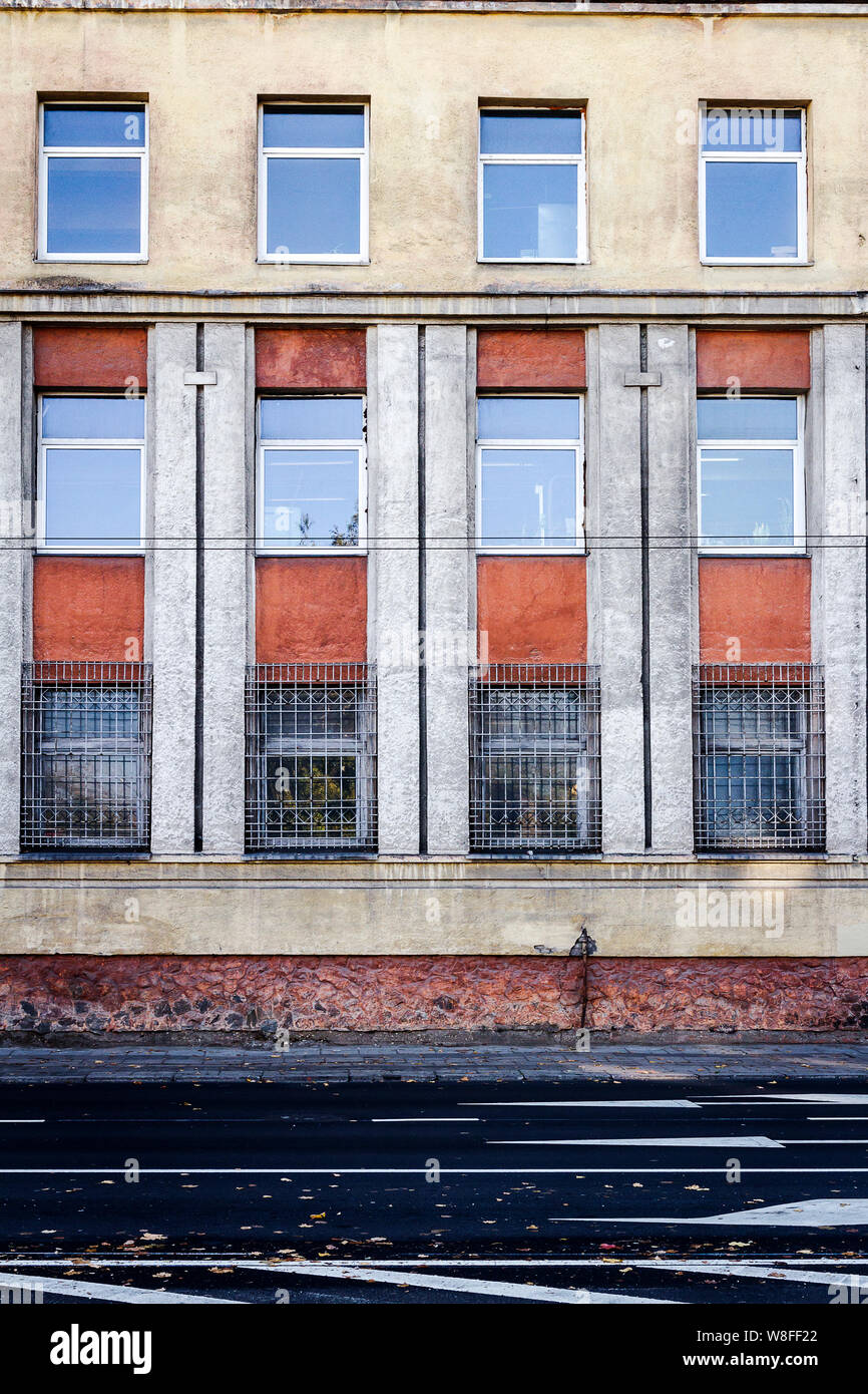 Close up of yellow and red wall with lots of windows. Architectural