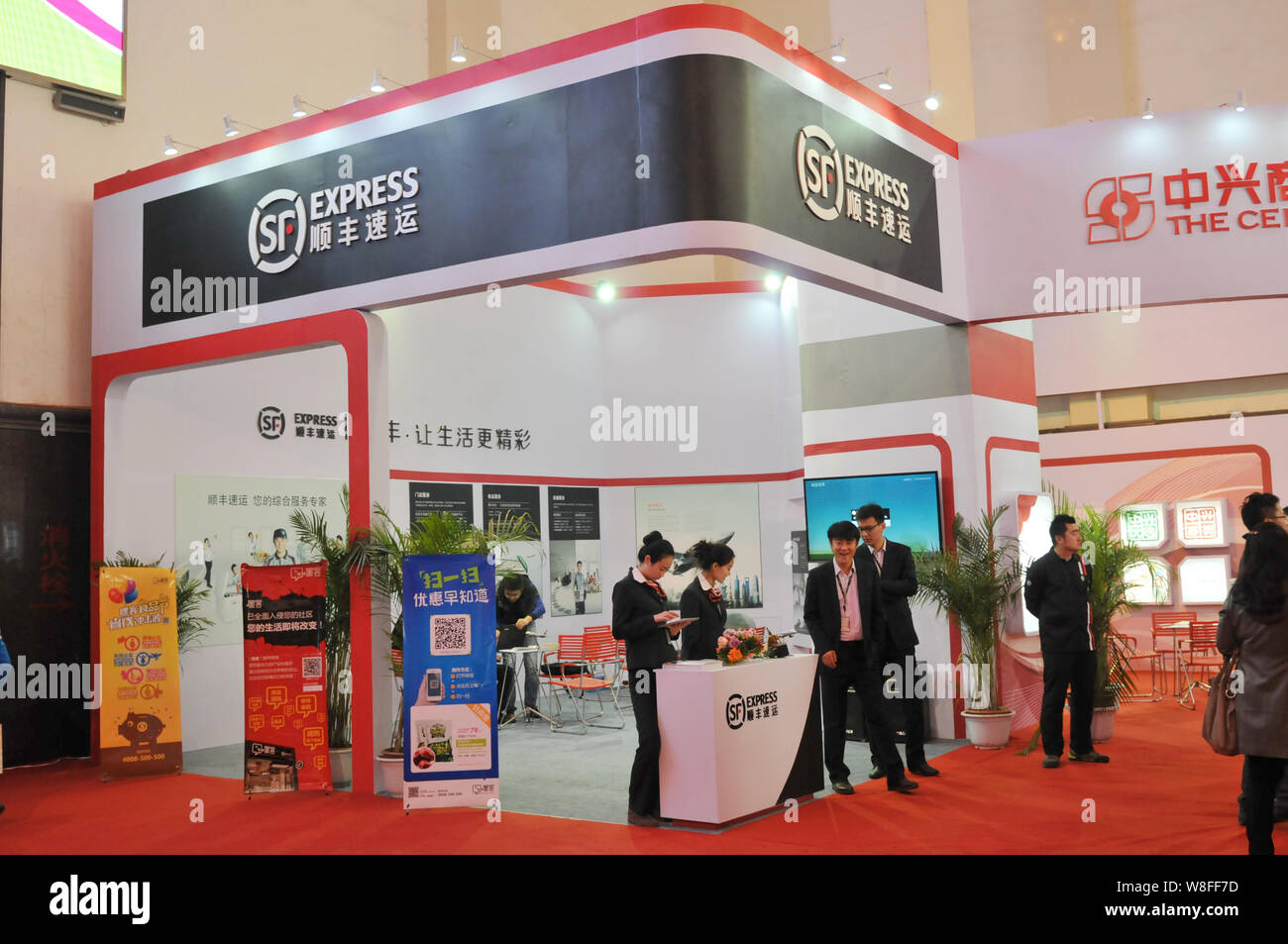 --FILE--Chinese employees are seen at the stand of SF Express during an exhibition in Shenyang city, northeast Chinas Liaoning province, 21 November 2 Stock Photo