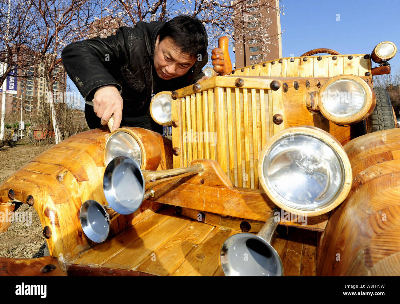 Chinese carpenter Liu Fulong checks his third homemade wooden electric