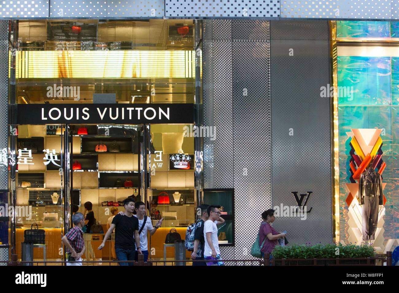 FILE--Pedestrians walk past a Louis Vuitton (LV) boutique of LVMH Moet  Hennessy Louis Vuitton SA in Hong Kong, China, 20 July 2015. LVMH Moet He  Stock Photo - Alamy