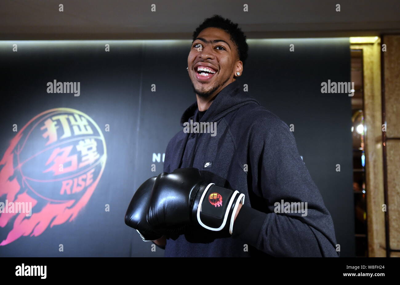NBA star Anthony Davis wearing boxing gloves poses at a media event in