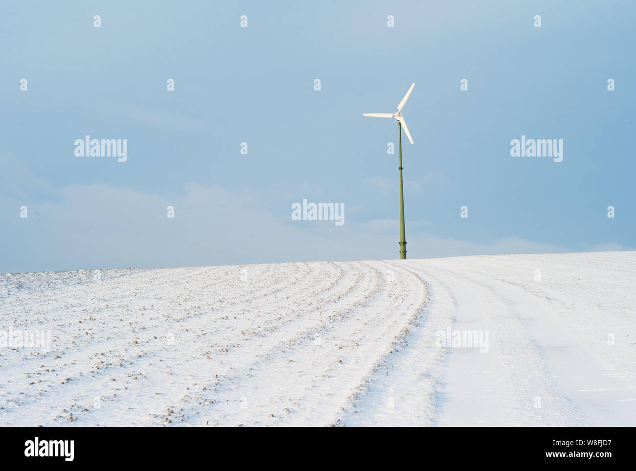 Electric Wind Power Plant on a Snow Covered Hill - A Concept For Renewable Energy Stock Photo
