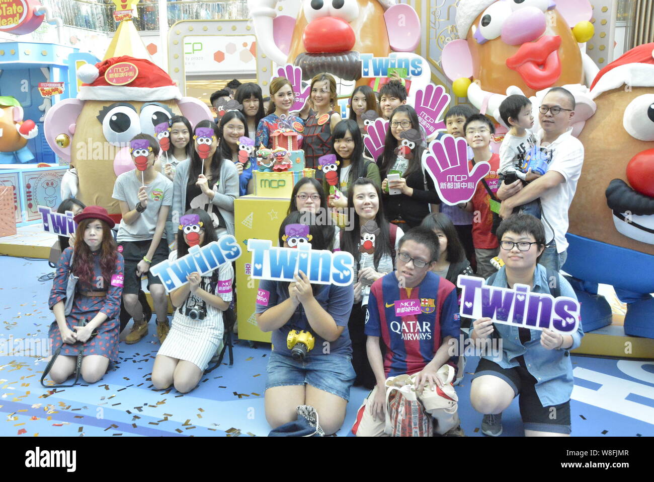 Gillian Chung, center left, and Charlene Choi, center right, of Hong Kong pop duo Twins pose with fans during the opening ceremony of Mr. Potato Head Stock Photo