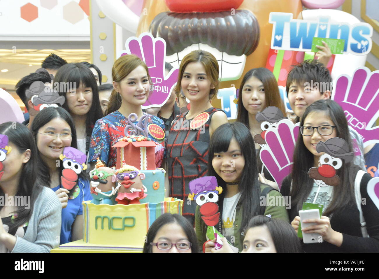 Gillian Chung, center left, and Charlene Choi, center right, of Hong Kong pop duo Twins pose with fans during the opening ceremony of Mr. Potato Head Stock Photo
