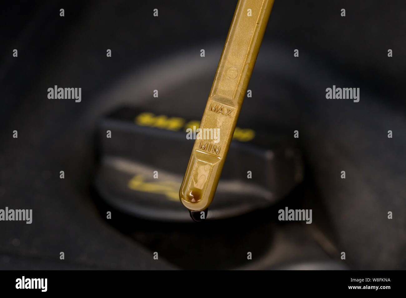 Closeup of car engine oil fill cap and yellow handle dipstick on motor Stock Photo