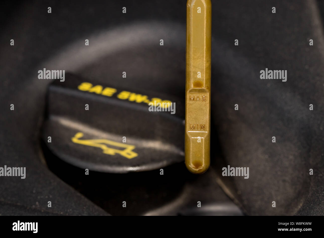 Closeup of car engine oil fill cap and yellow handle dipstick on motor Stock Photo