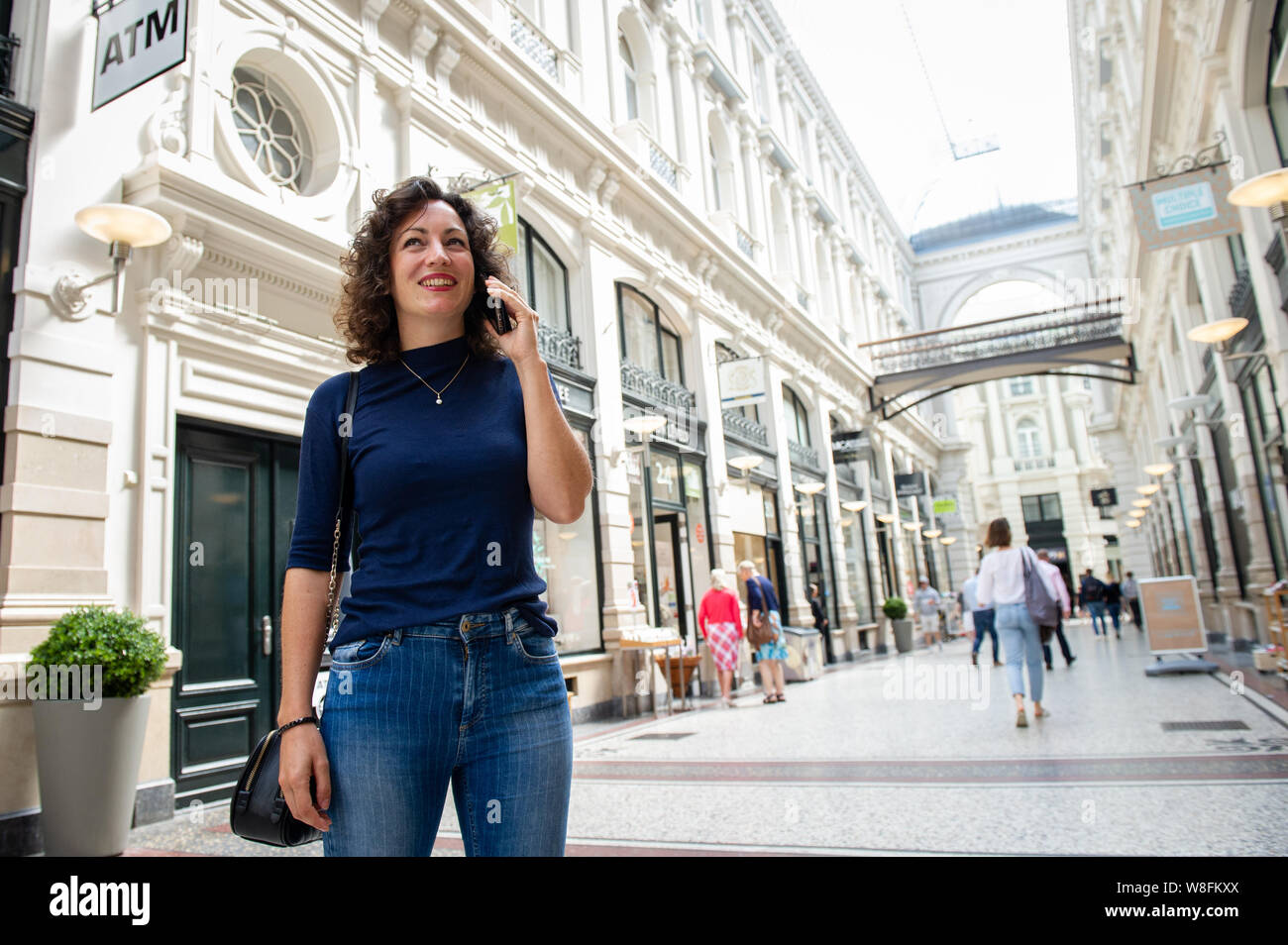 Den Haag. Passage. Een jonge vrouw aan het bellen met haar mobiel.  Foto: Gerrit de Heus. The Netherlands. A young woman talking on her mobile phone. Stock Photo
