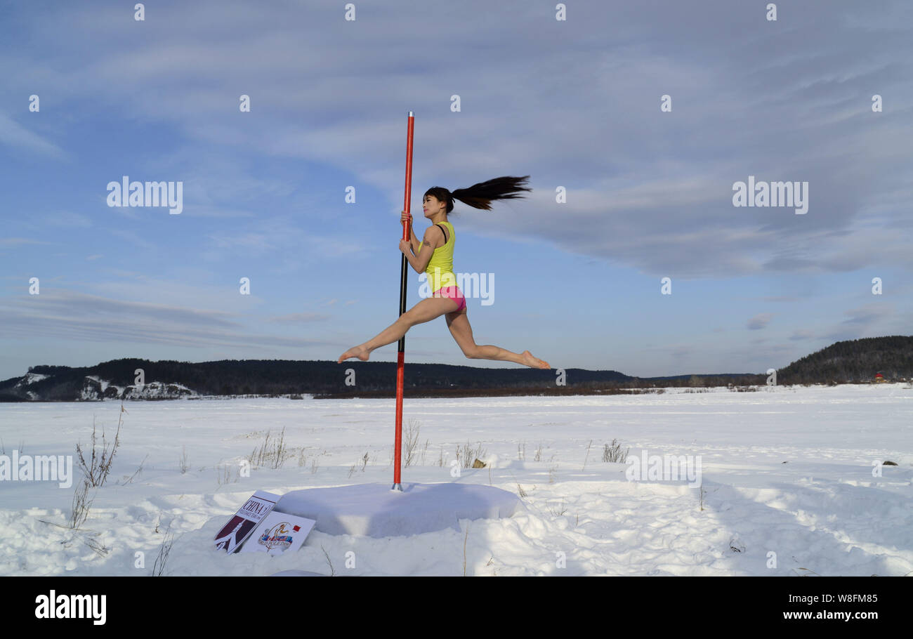 --FILE--A member of China's National Pole Dancing Team performs in the snow in Mohe city, northeast China's Heilongjiang province, 23 December 2014. Stock Photo