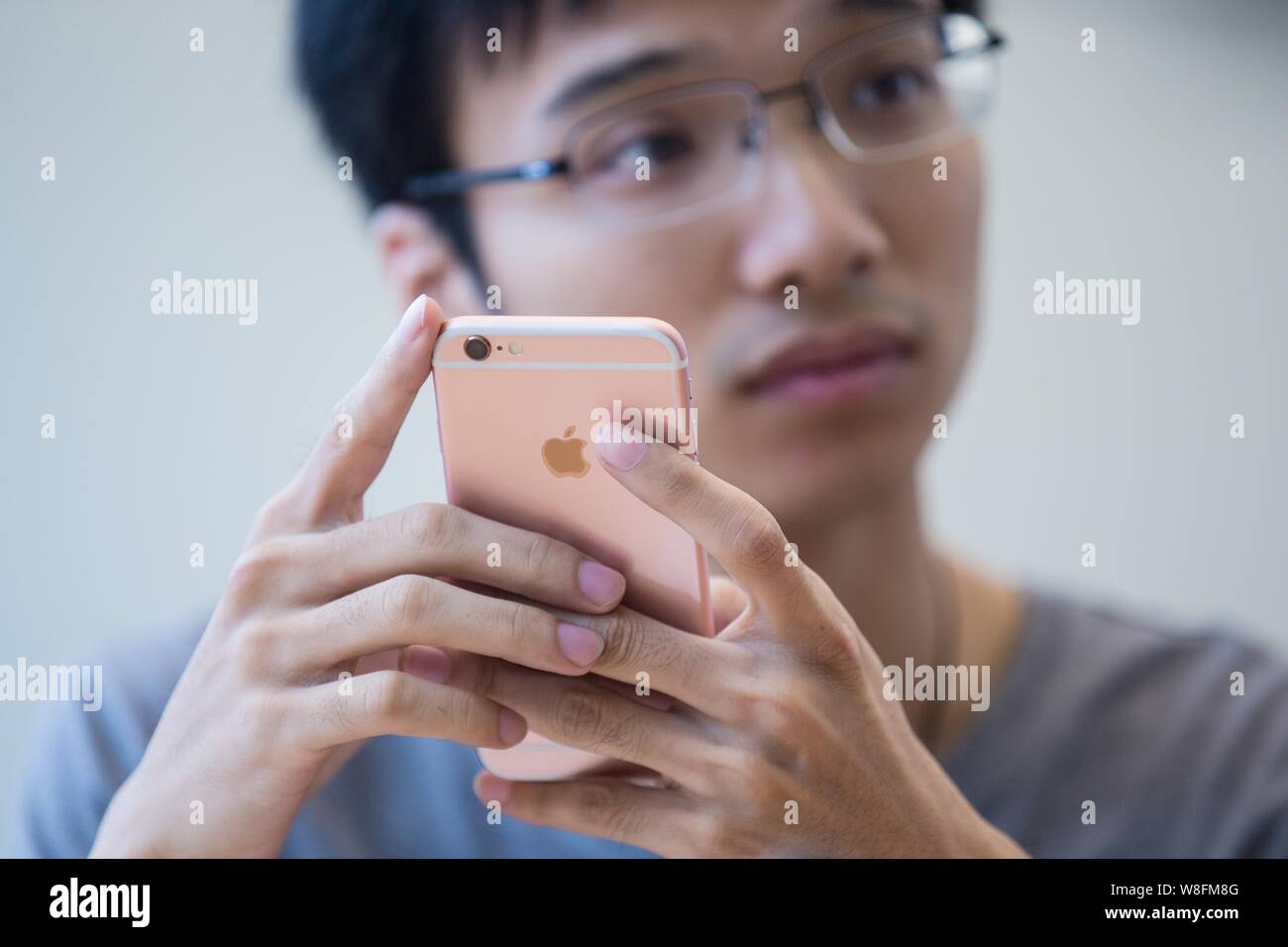 A customer tries out a rose gold iPhone 6s smartphone at the Apple Store near the West Lake in Hangzhou city, east China's Zhejiang province, 25 Septe Stock Photo