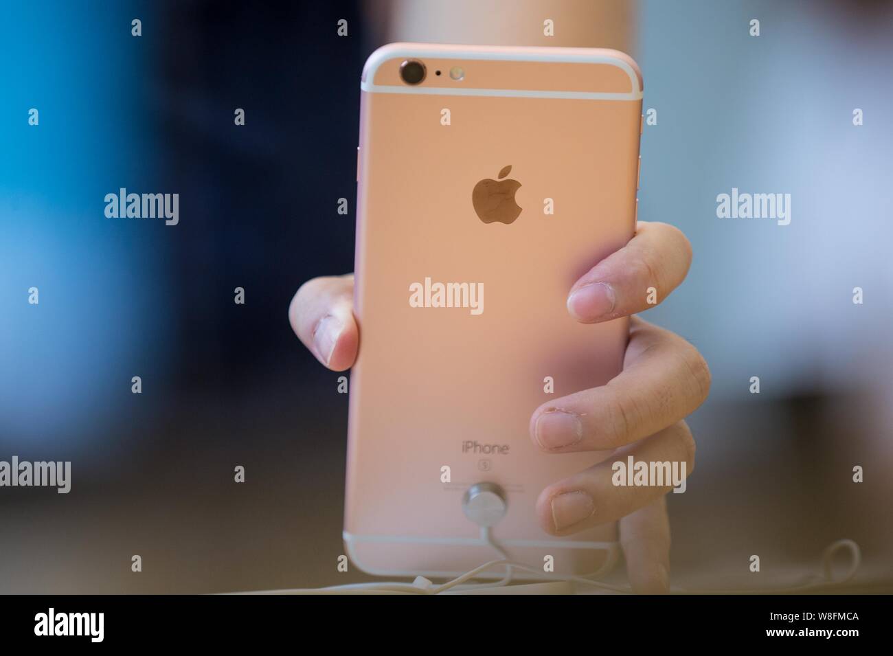 A customer tries out a rose gold iPhone 6s Plus smartphone at the Apple Store near the West Lake in Hangzhou city, east China's Zhejiang province, 25 Stock Photo