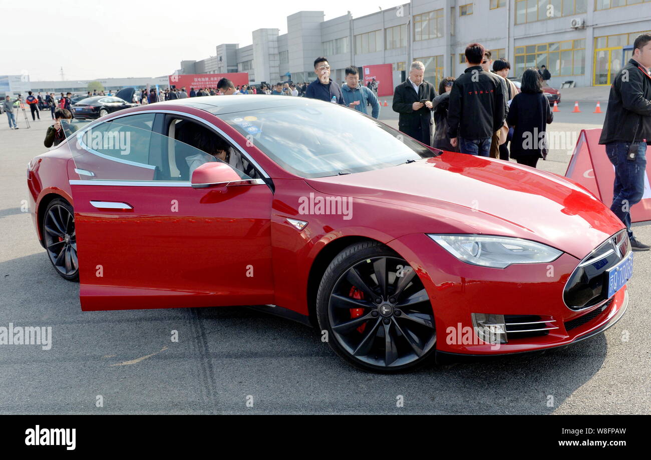 FILE--Visitors try out Tesla Model S electric cars at a delivery ceremony in Beijing, April 2015. Entrepreneur Elon Musk has launche Stock Photo - Alamy
