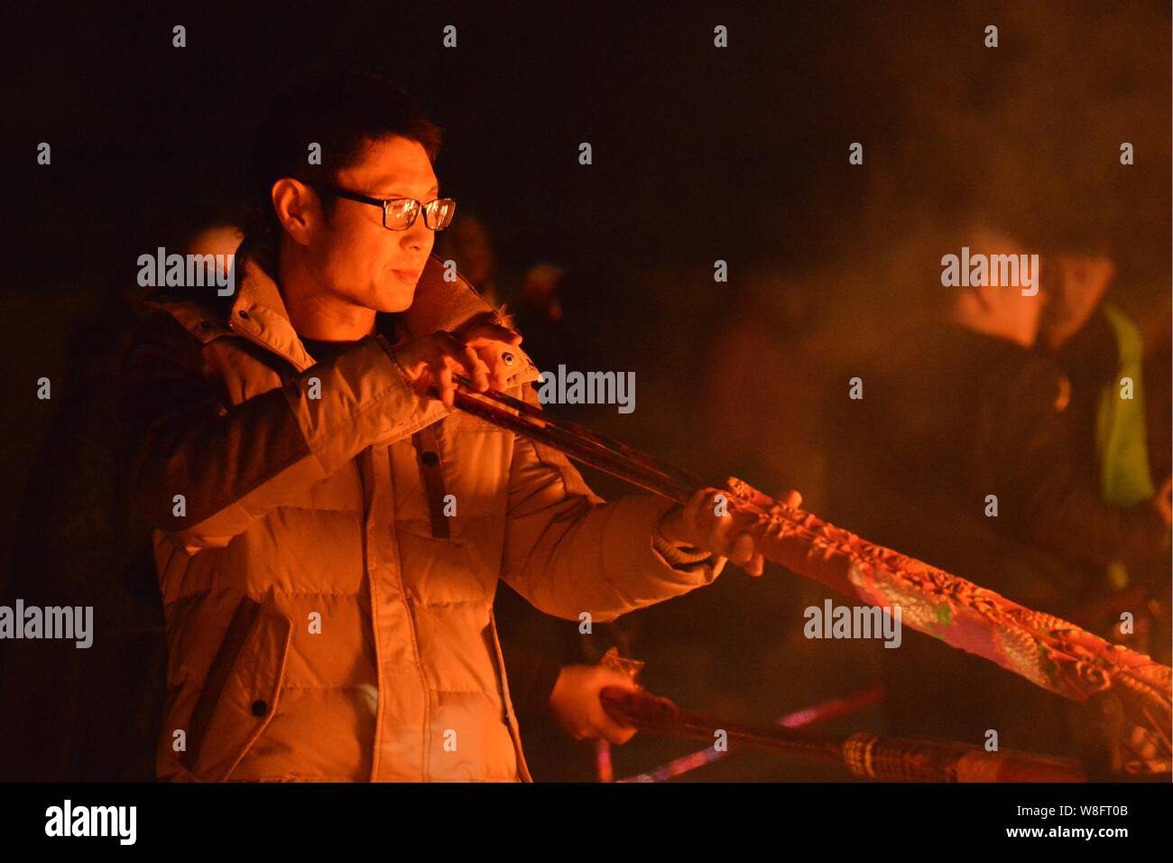 A Chinese worshipper burns incense sticks to pray for good fortune and celebrate the Year of the Ram on the first day of Chinese Lunar New Year at the Stock Photo