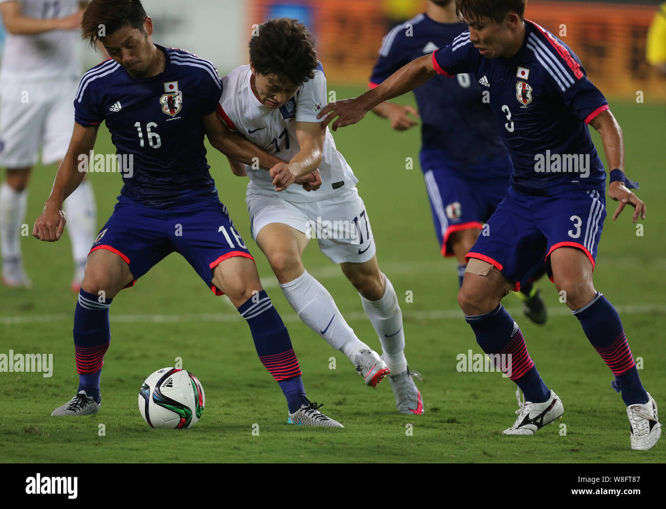 Hotaru Yamaguchi, left, and Ota Kosuke, right, of Japan challenge Lee Sung-Jae of South Korea during their soccer match of the Men's East Asian Cup 20 Stock Photo