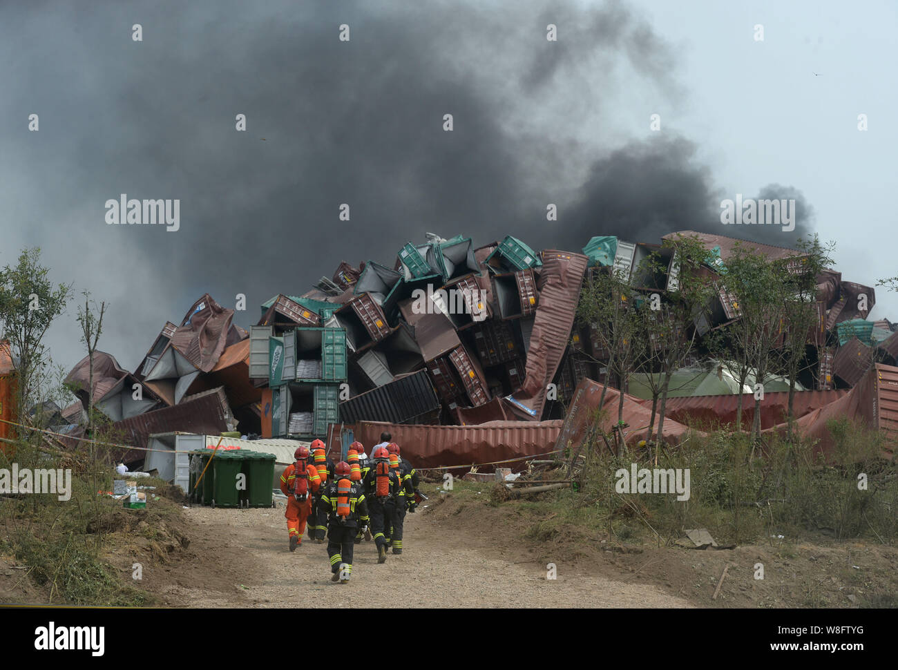 Chinese firefighters walk towards the core area of the blasts site for rescue missions after the deadly explosions in Binhai New Area in Tianjin, Chin Stock Photo