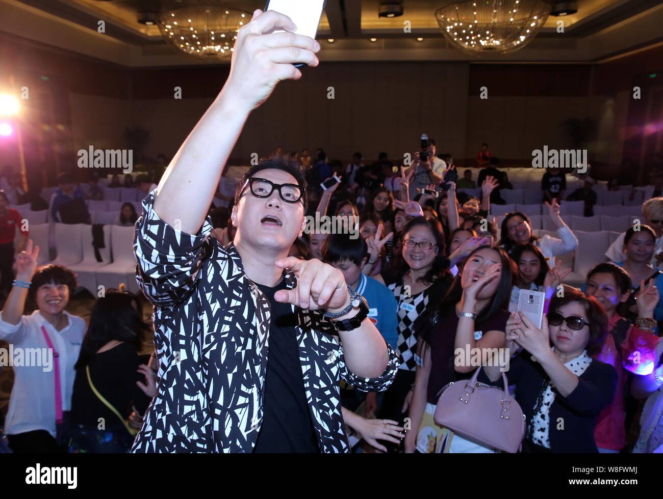 South Korean singer Jeong Soon-won, left, better known by his stage name  The One, takes selfies with fans during a press conference for his Chinese  al Stock Photo - Alamy