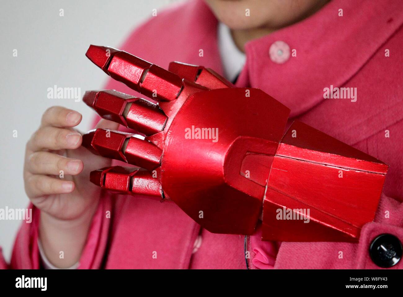 A woman tries on a hand protector of Chinese "Iron Man" fan Cheng Chen's  homemade plastic Iron Man armor at his home in Xuzhou city, east China's  Jian Stock Photo - Alamy