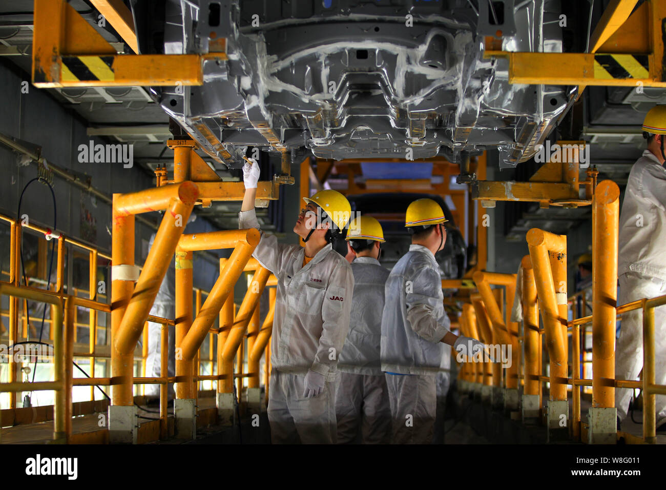 --FILE--Chinese workers assemble a car on the assembly line at the auto ...