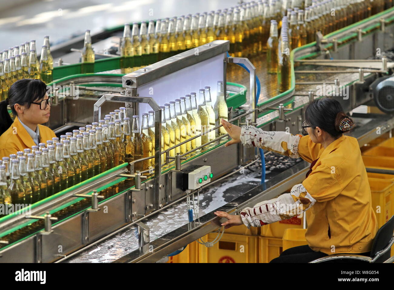 --FILE--Chinese workers monitor a beer production line at a brewery in ...