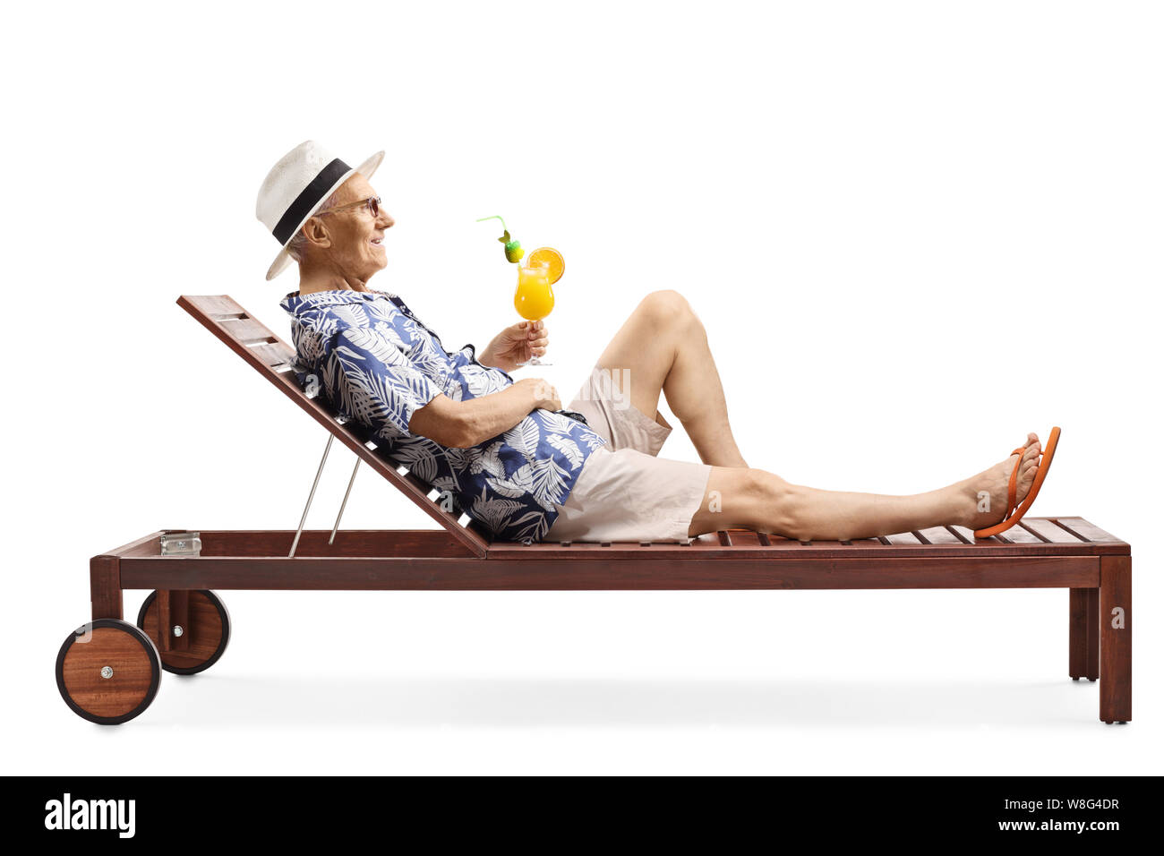 Full length profile shot of a senior man relaxing on a beach bed with a cocktail isolated on white background Stock Photo