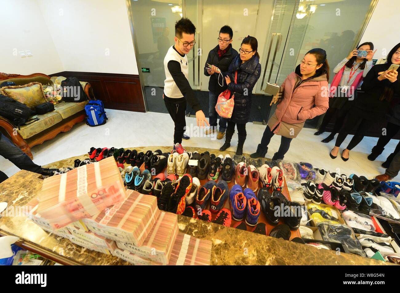 30-year-old Chinese man Mick, left, the owner of 283 pairs of Nike Jordan sneakers, introduces the shoes he pawned off to make down-payment on an apar Stock Photo