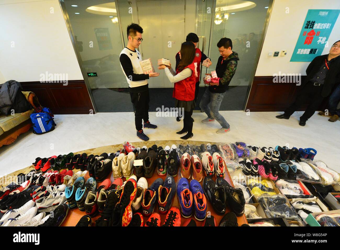 30-year-old Chinese man Mick, left, the owner of 283 pairs of Nike Jordan sneakers, gets money after pawning off the shoes to make down-payment on an Stock Photo