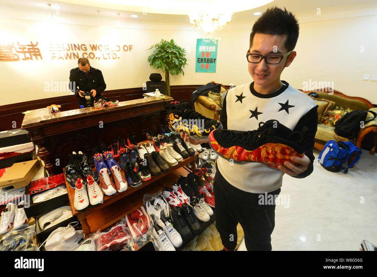 30-year-old Chinese man Mick, the owner of 283 pairs of Nike Jordan sneakers, looks at the shoes he pawned off to make down-payment on an apartment at Stock Photo