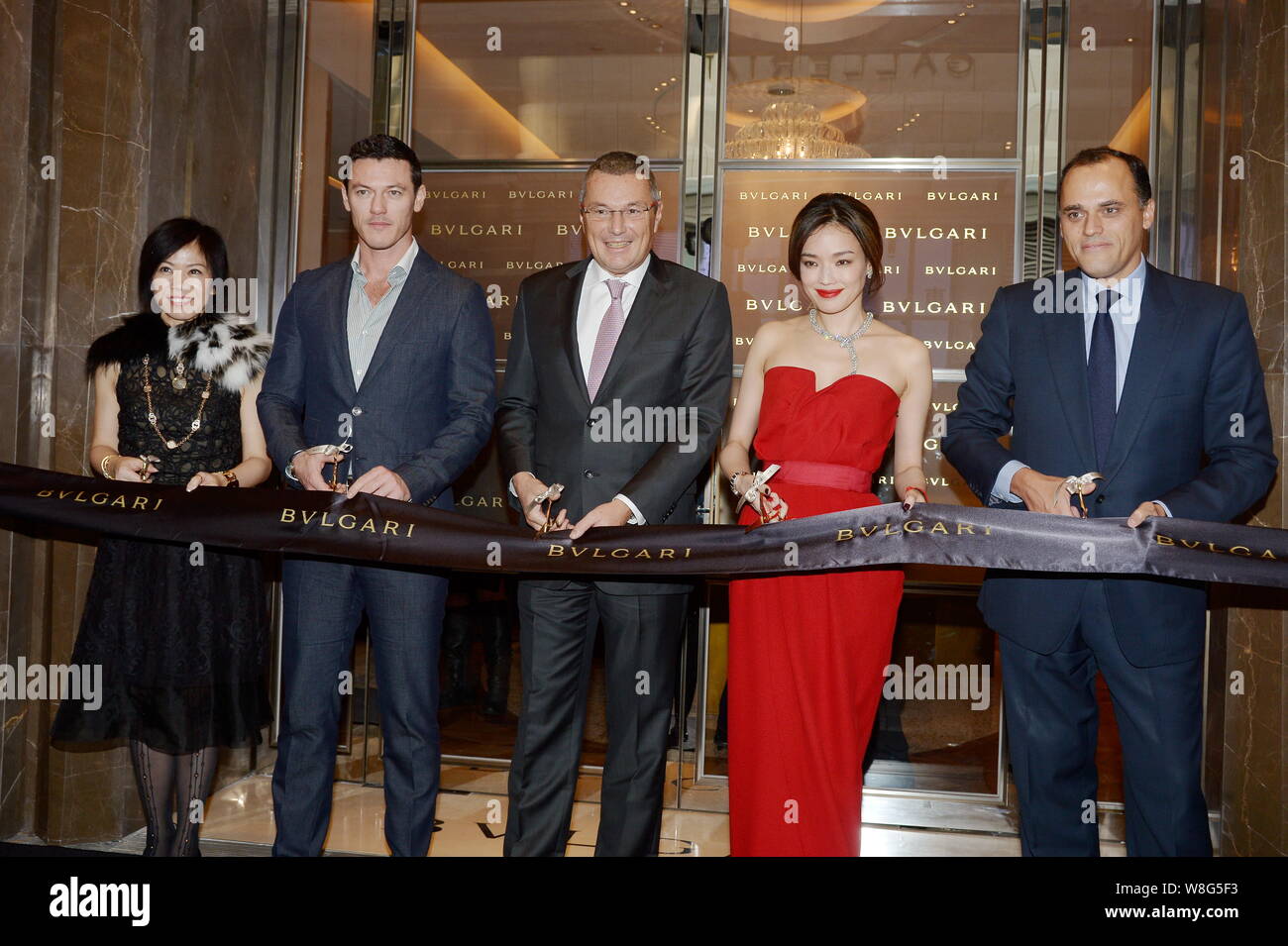 Taiwanese actress Shu Qi, second right, and British actor Luke Evans, second left, cut the ribbon with Bulgari CEO Jean-Christophe Babin, center, and Stock Photo