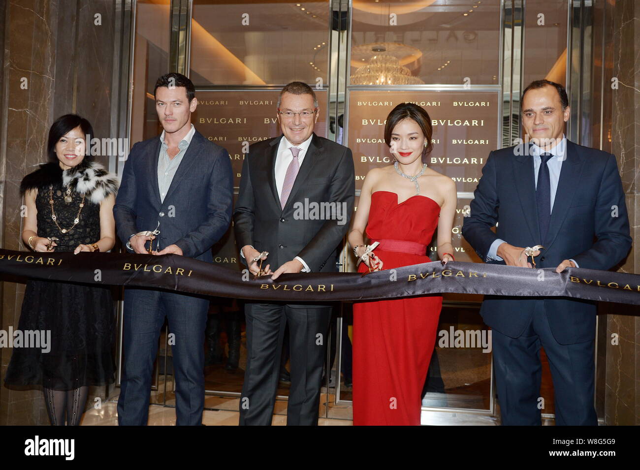 Taiwanese actress Shu Qi, second right, and British actor Luke Evans, second left, cut the ribbon with Bulgari CEO Jean-Christophe Babin, center, and Stock Photo
