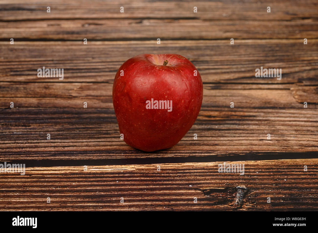 Ripe red Apple on wooden table background. Stock Photo