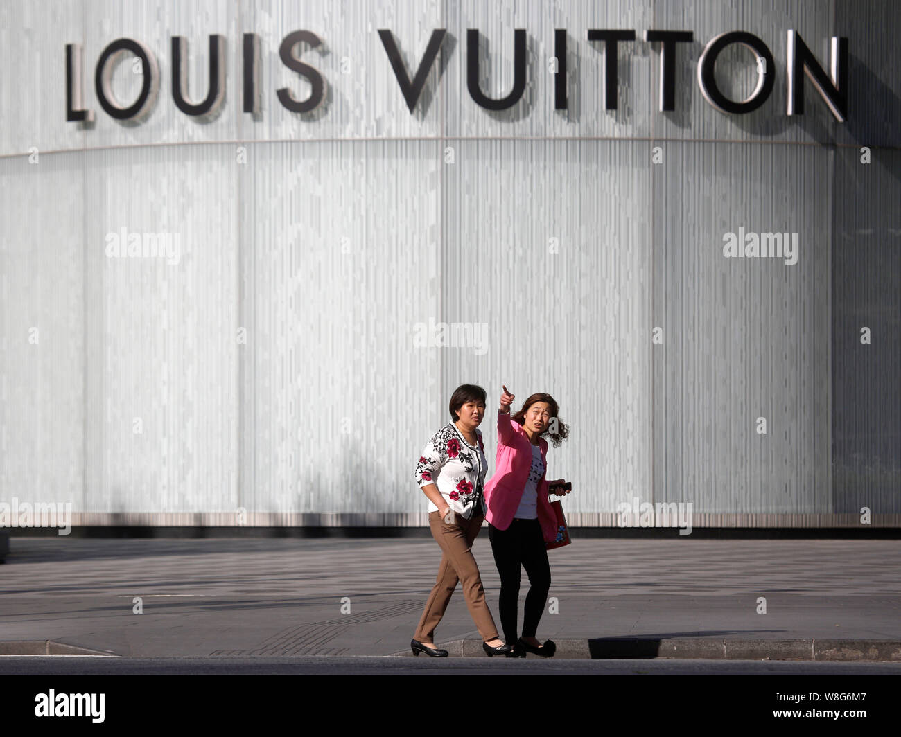 FILE--Pedestrians walk past a fashion boutique of Louis Vuitton (LV) in  Shanghai, China, 12 May 2015. LVMH Moet Hennessy Louis Vuitton SE said Mon  Stock Photo - Alamy